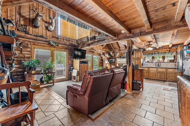 living room featuring wood walls, wood ceiling, sink, and ceiling fan