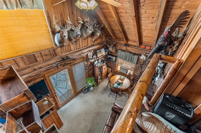 carpeted living room with wood walls, beam ceiling, and wooden ceiling