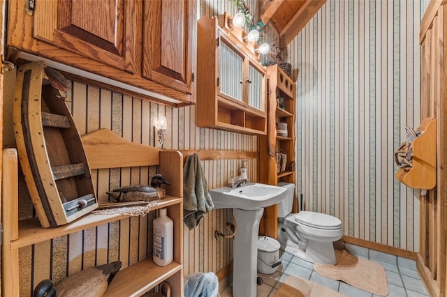 bathroom featuring tile patterned flooring, toilet, and wooden walls