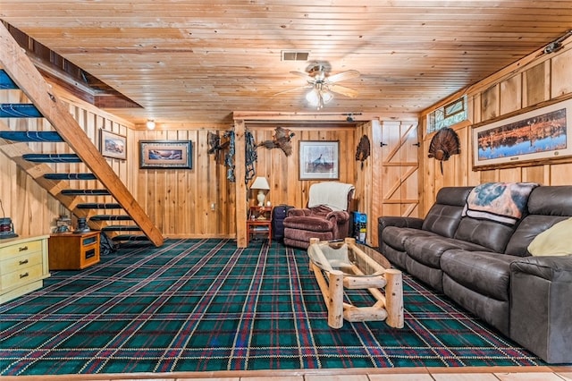 unfurnished living room featuring wooden ceiling, dark colored carpet, wood walls, and ceiling fan