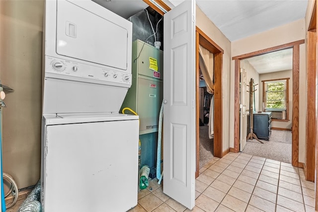 clothes washing area featuring light tile patterned flooring and stacked washing maching and dryer