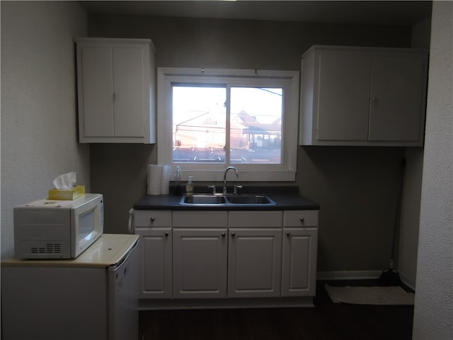 kitchen featuring white cabinetry, dark hardwood / wood-style flooring, and sink