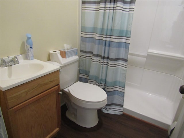 bathroom featuring wood-type flooring, toilet, walk in shower, and vanity