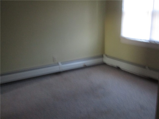 unfurnished room featuring carpet flooring and baseboard heating