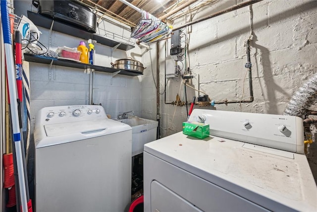 clothes washing area featuring laundry area, independent washer and dryer, and a sink