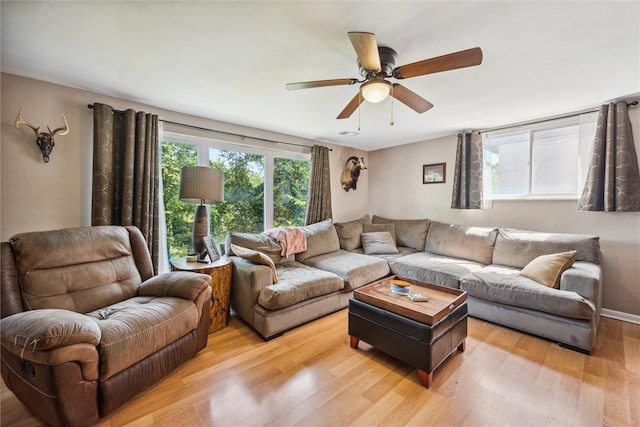 living room with light hardwood / wood-style flooring and ceiling fan