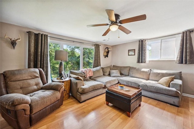 living room with a ceiling fan and light wood-type flooring