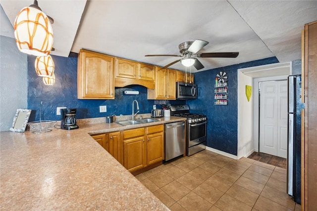 kitchen featuring a ceiling fan, light tile patterned flooring, a sink, stainless steel appliances, and light countertops