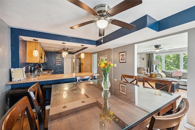 dining room with ceiling fan and sink