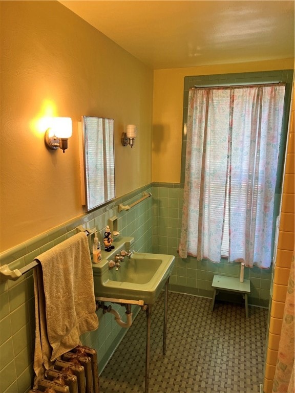 bathroom featuring sink and tile walls