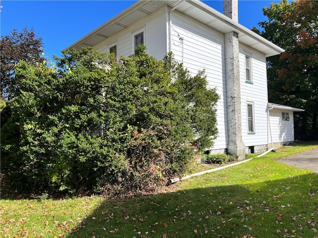 view of side of home with a yard