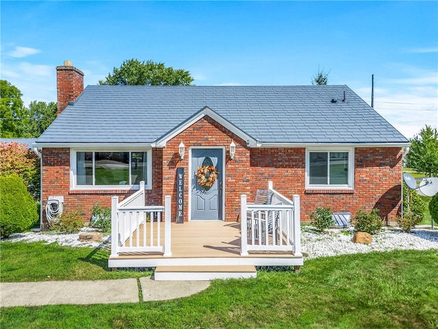 bungalow-style house with a deck and a front lawn