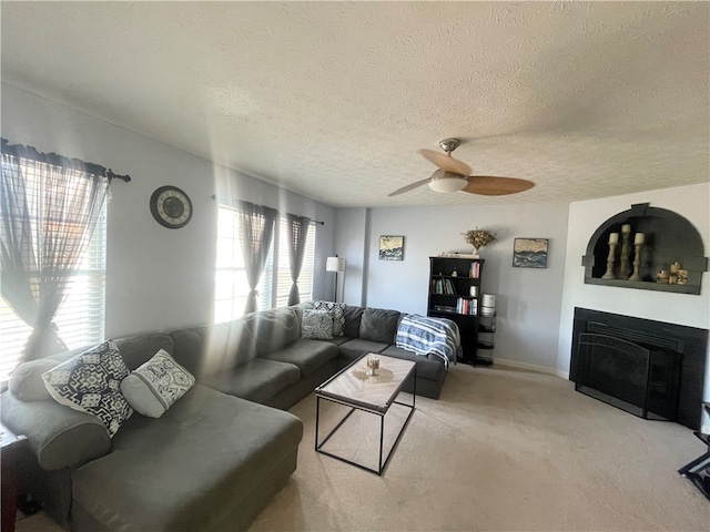 carpeted living room featuring a textured ceiling and ceiling fan