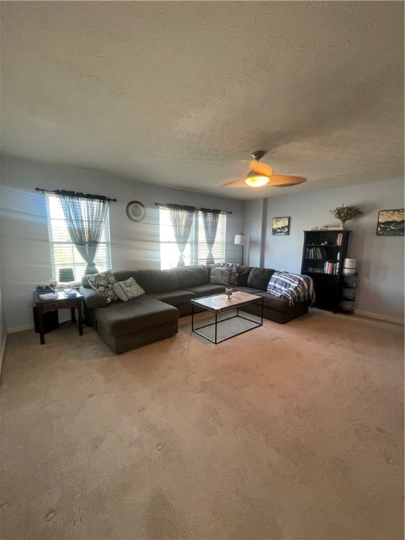 unfurnished living room with a textured ceiling, carpet, and ceiling fan