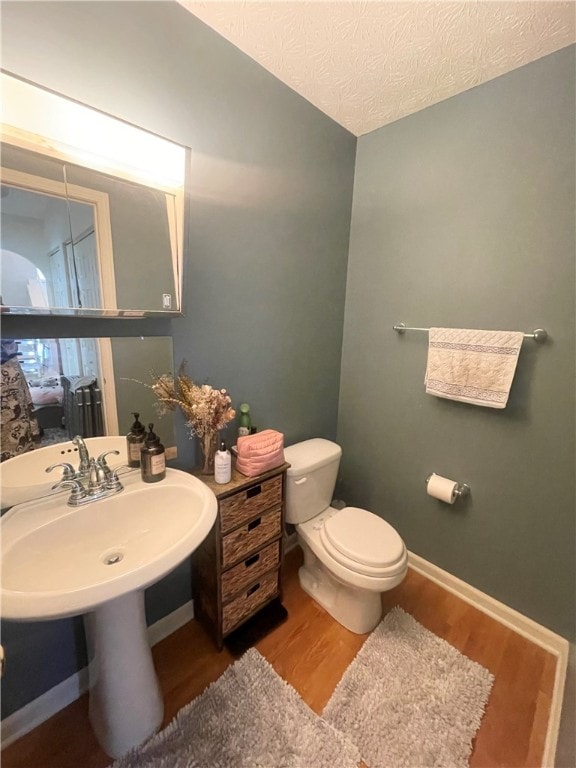 bathroom with toilet and hardwood / wood-style flooring