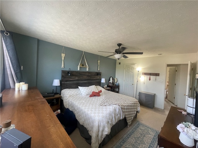 bedroom featuring a textured ceiling, ceiling fan, and carpet floors