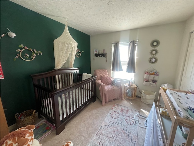 carpeted bedroom featuring a crib and a textured ceiling