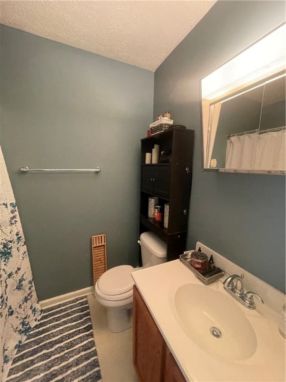 bathroom featuring toilet, a textured ceiling, and vanity