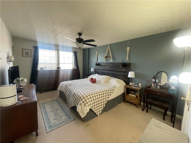 bedroom featuring ceiling fan, light carpet, and a textured ceiling