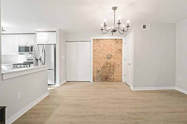 unfurnished dining area featuring light hardwood / wood-style floors and a notable chandelier