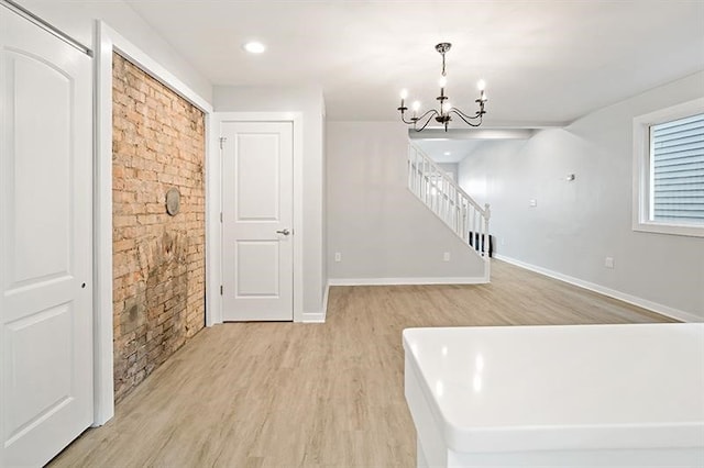 unfurnished dining area featuring light hardwood / wood-style flooring and a notable chandelier