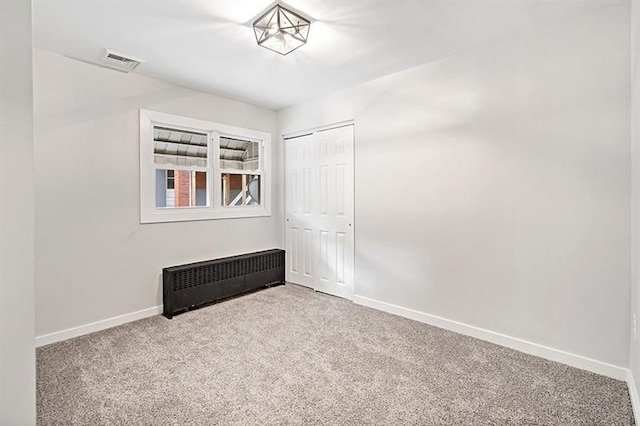 empty room with radiator and carpet