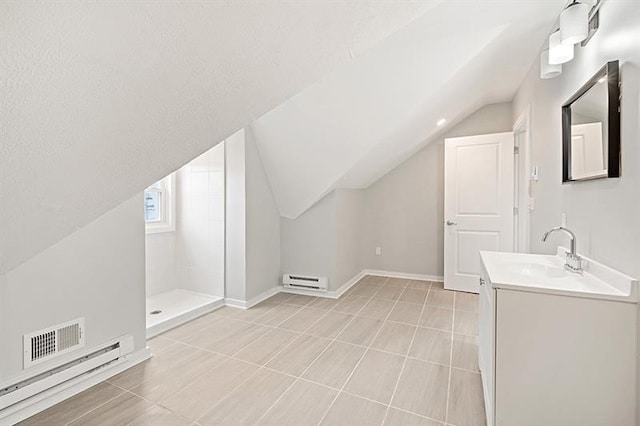 interior space with walk in shower, a baseboard radiator, vaulted ceiling, and vanity