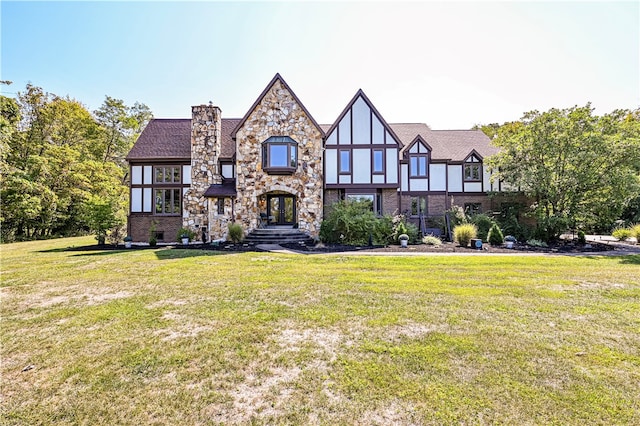 tudor-style house featuring a front yard