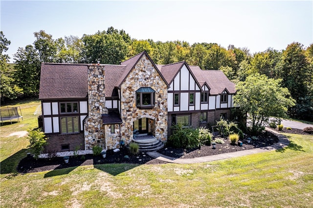 tudor house featuring a trampoline and a front yard