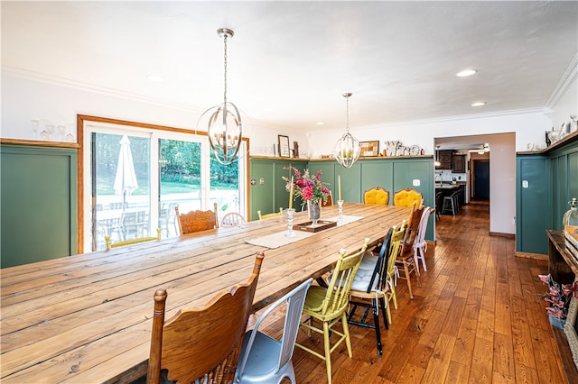 dining space featuring ornamental molding, dark hardwood / wood-style floors, and a notable chandelier