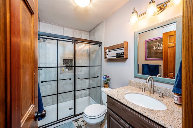 bathroom with vanity, toilet, and a shower with door