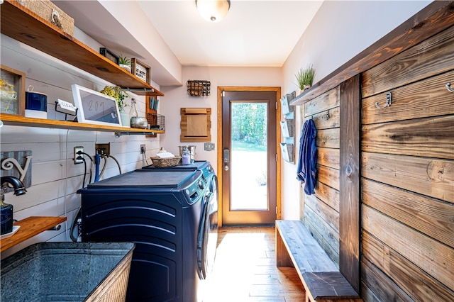 clothes washing area with a wealth of natural light, washer and clothes dryer, and hardwood / wood-style flooring