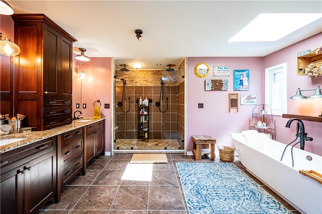 bathroom featuring vanity, separate shower and tub, and a skylight