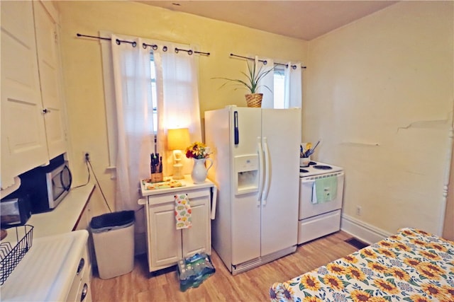 kitchen featuring white appliances, white cabinets, and light hardwood / wood-style floors