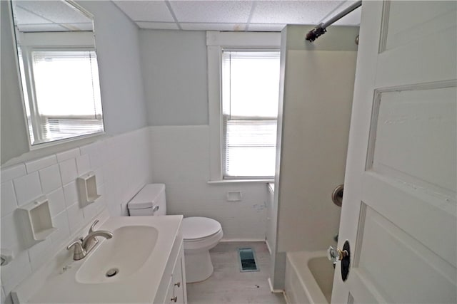 full bathroom with a wealth of natural light, vanity, toilet, and a paneled ceiling