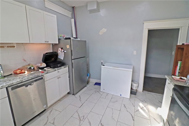 kitchen featuring white cabinets, appliances with stainless steel finishes, and light stone counters