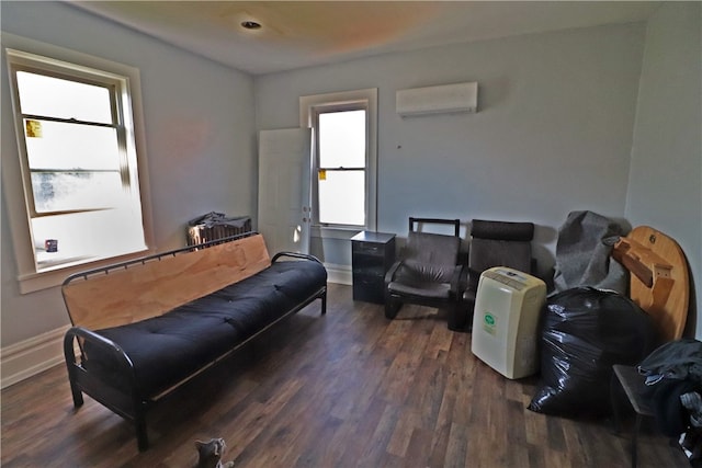 living room featuring dark wood-type flooring, plenty of natural light, and a wall mounted air conditioner