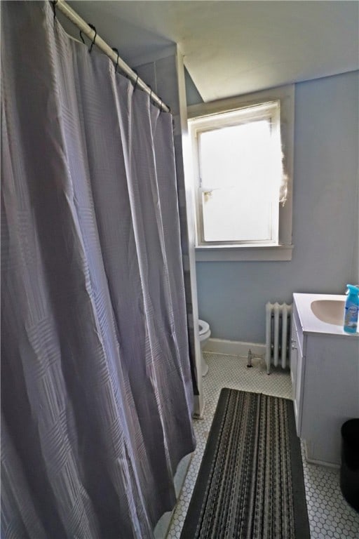 bathroom with toilet, walk in shower, tile patterned floors, vanity, and radiator heating unit