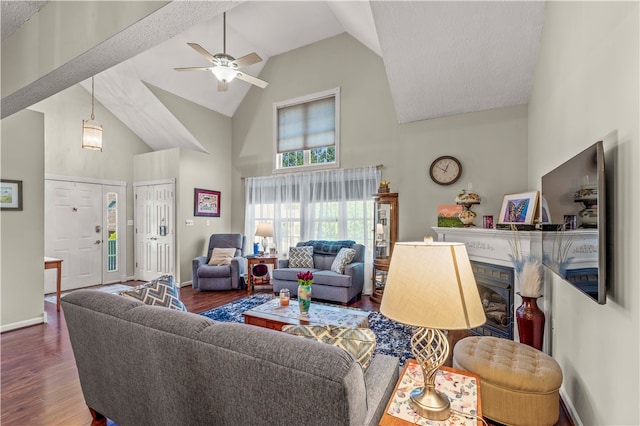 living room with high vaulted ceiling, wood-type flooring, ceiling fan, and a textured ceiling