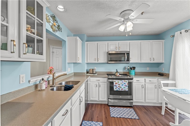 kitchen featuring white cabinetry, stainless steel appliances, dark hardwood / wood-style flooring, sink, and ceiling fan