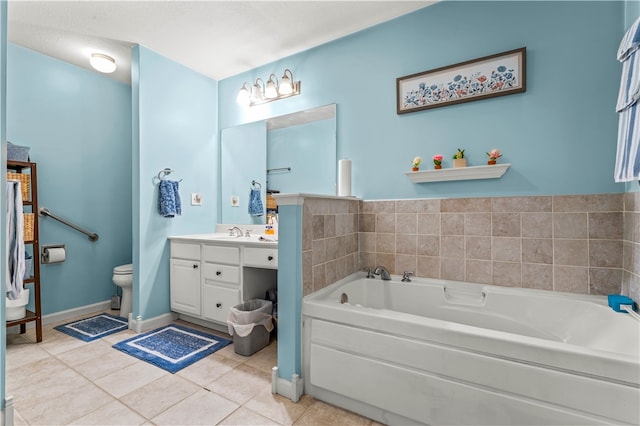 bathroom with tile patterned floors, a tub to relax in, toilet, vanity, and a textured ceiling