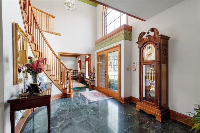 foyer entrance with a towering ceiling and a notable chandelier