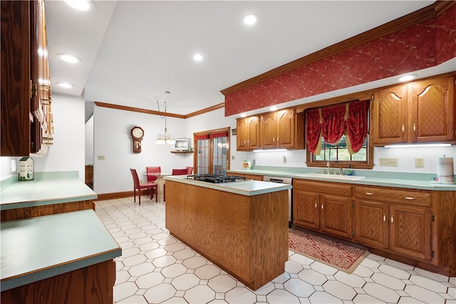 kitchen featuring pendant lighting, crown molding, stainless steel appliances, a kitchen island, and sink