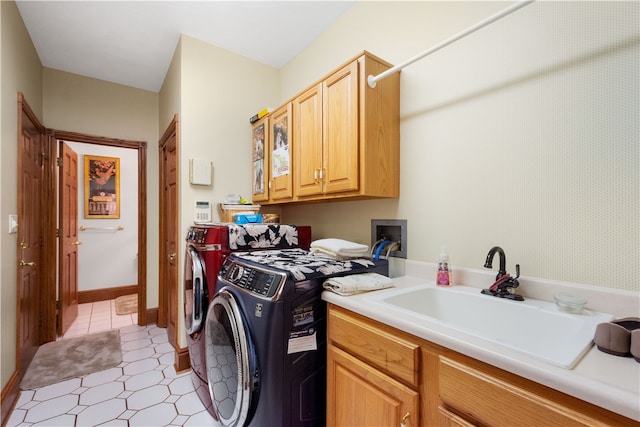 clothes washing area featuring cabinets, washer and clothes dryer, and sink