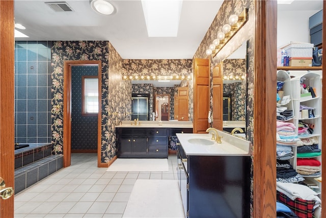 bathroom featuring vanity, a bath, and tile patterned floors