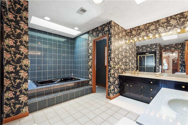 bathroom featuring tile patterned floors, tiled tub, and vanity