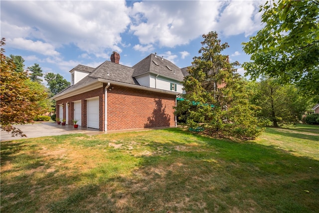 view of side of property featuring a garage and a lawn