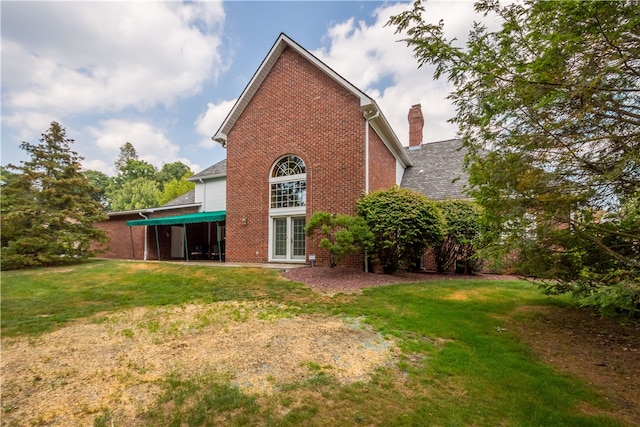 rear view of property with a lawn and a patio