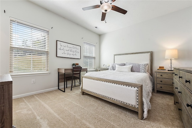 bedroom with light colored carpet, ceiling fan, and multiple windows