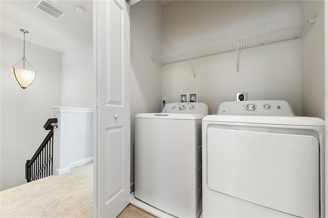 laundry area featuring light colored carpet and separate washer and dryer